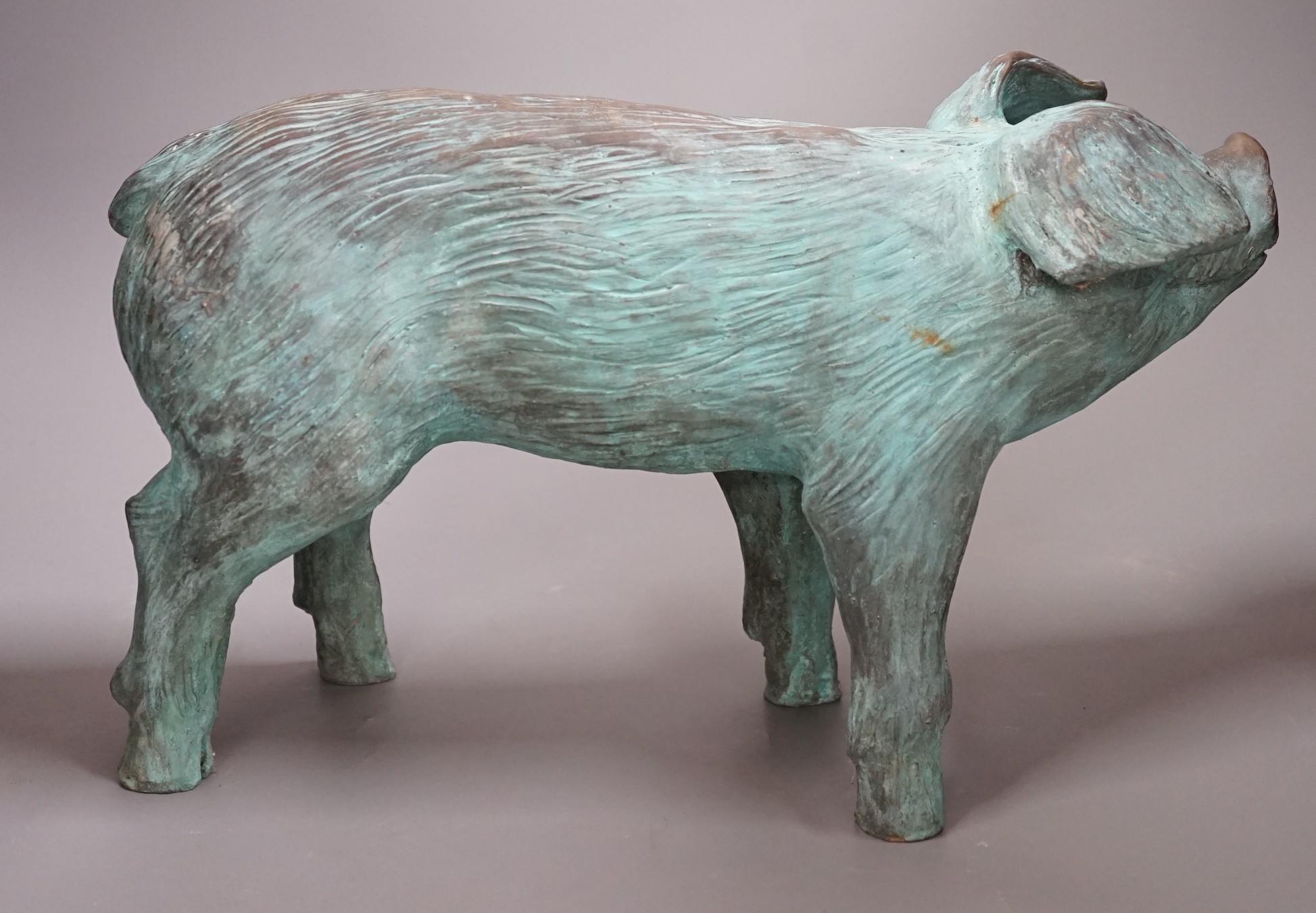 A cold cast resin bronze pig initialled 'JP', 40cm wide